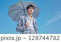 晴天の下で日傘をさすスーツ姿の若い男性 128744782
