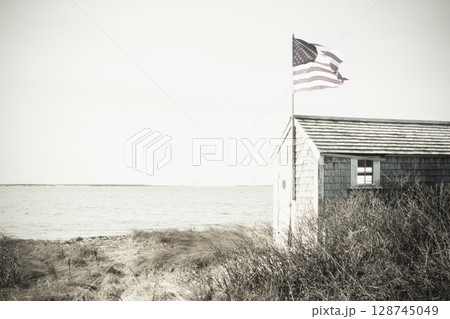 Seaside shed with American flag, black and white Seaside shed with American flag, black and white 128745049