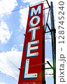 Low angle view of red and white Motel sign against sky 128745240