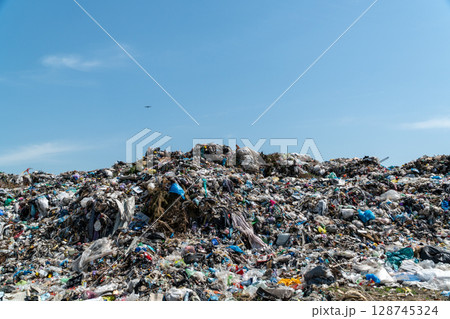 Mountains of garbage accumulate in a landfill site showcasing environmental pollution on a bright sunny day Mountains of garbage accumulate in a landfill site showcasing environmental pollution on a bright sunny day 128745324