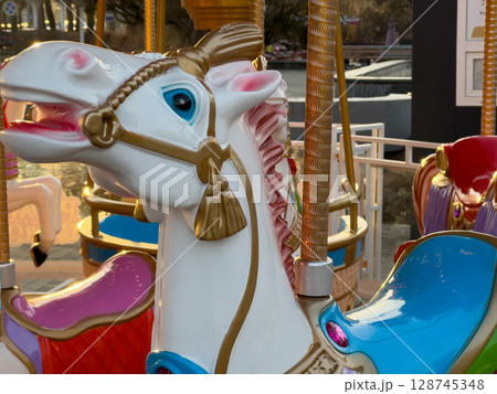 A beautifully designed carousel horse stands proudly at an amusement park, inviting children and families to enjoy a magical ride 128745348