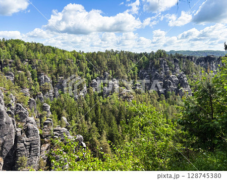 Beautiful spring landscape with rocky mountains and forest in Saxon Switzerland National Park on a sunny day. Beautiful spring landscape with rocky mountains and forest in Saxon Switzerland National Park on a sunny day. 128745380