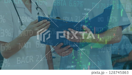 Image of stock market data processing over female doctor and health worker examining reports Image of stock market data processing over female doctor and health worker examining reports 128745863