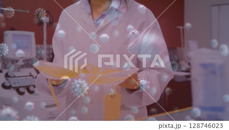 Image of virus cells over female scientist with bags 128746023