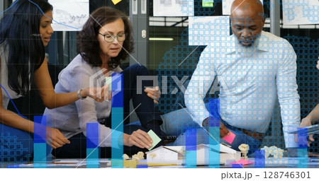 Image of statistical data processing against diverse office colleagues reading memo notes Image of statistical data processing against diverse office colleagues reading memo notes 128746301