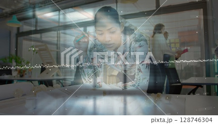 Image ofdata processing against african american female engineer working on her model at office Image ofdata processing against african american female engineer working on her model at office 128746304