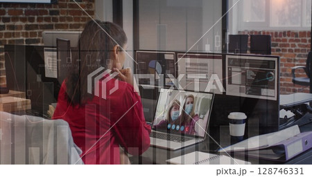 Statistical data processing over rear view of a woman having a image call on laptop at office 128746331