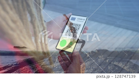 Image of man with covid passport on smartphone over woman practicing yoga on beach Image of man with covid passport on smartphone over woman practicing yoga on beach 128747139