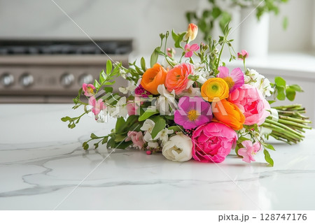 Bright bouquet of colorful flowers on a marble kitchen countertop 128747176