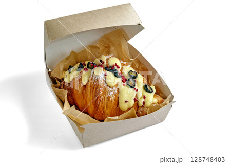 appetizing croissant with blueberries in a cardboard box isolated on a white background 128748403