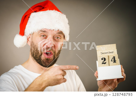 December 24th. Man santa hat holds calender December 24th. Man santa hat holds calender 128748793