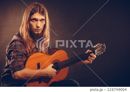 Guitarist trying out chords. 128749004