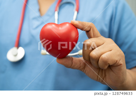Asian woman doctor holding red heart for health in hospital. Asian woman doctor holding red heart for health in hospital. 128749633