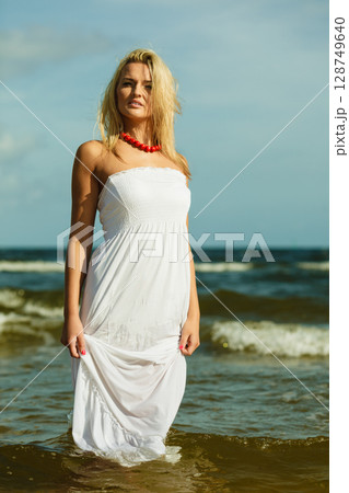 Beautiful blonde girl on beach, summertime 128749640