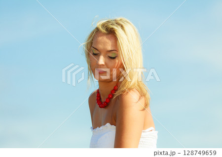 Beautiful woman wearing white dress, sky background Beautiful woman wearing white dress, sky background 128749659