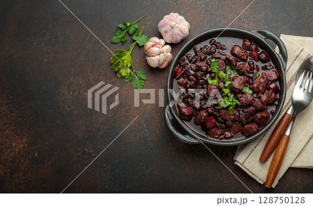 Brazilian feijoada with black beans, sausage, and meat in a pot, top view Brazilian feijoada with black beans, sausage, and meat in a pot, top view 128750128