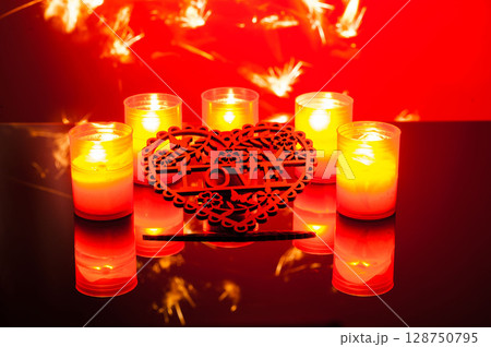 On a colorful background, small candles flicker brightly On a colorful background, small candles flicker brightly 128750795