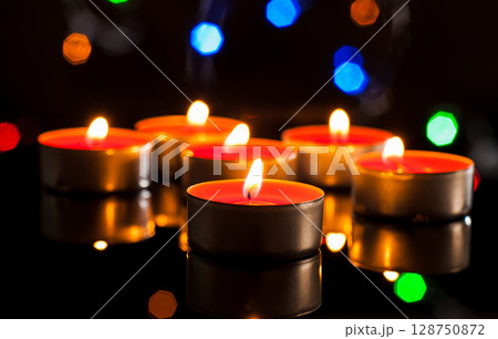Dozens of candles shine like sparks of hope in the darkness Dozens of candles shine like sparks of hope in the darkness 128750872