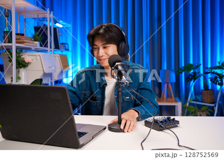 Young man smiling while hosting podcast session 128752569