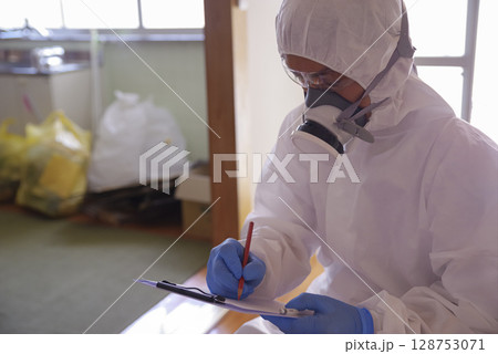 ゴミ屋敷清掃現場の防護服作業員 ゴミ屋敷清掃現場の防護服作業員 128753071