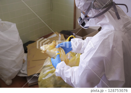 防護服で作業する特殊清掃員 防護服で作業する特殊清掃員 128753076