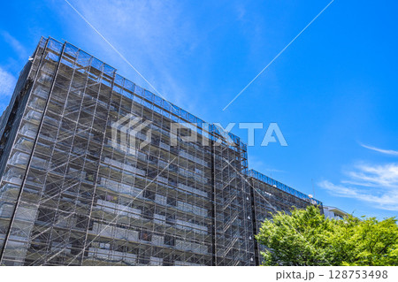 日本の横浜都市景観　マンションの補修や点検等、足場や防護ネットなどを望む。衛星アンテナが… 128753498