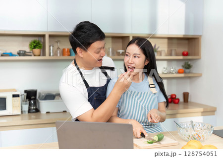 Healthy Cooking Together: Couple Sharing Ingredients in Bright Kitchen Healthy Cooking Together: Couple Sharing Ingredients in Bright Kitchen 128754051