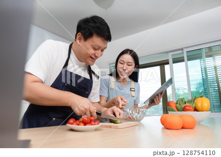 Cooking Together: Couple Chopping Fresh Vegetables in Modern Kitchen 128754110