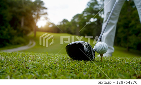 Golfer putting ball on the green golf, lens flare on sun set evening time. 128754270