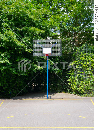 Outdoor basketball court in a park where people can enjoy playing and recreational activities. Outdoor basketball court in a park where people can enjoy playing and recreational activities. 128754432