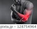 Man suffering from elbow pain, highlighted in red, is holding his arm 128754964