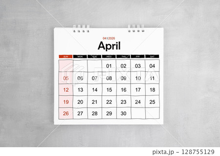 April 2026 desk calendar on gray cement wall background. Page of annual monthly calendar. 128755129