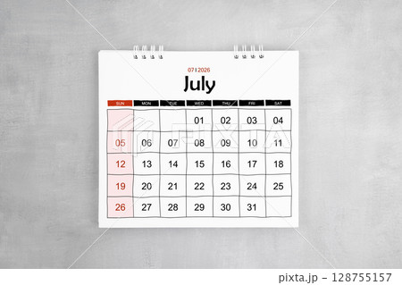 July 2026 desk calendar on gray cement wall background. Page of annual monthly calendar. 128755157