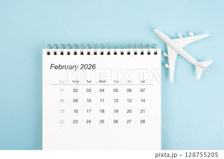 February 2026 calendar and airplane toy on blue color background, Travel plan concepts. 128755205