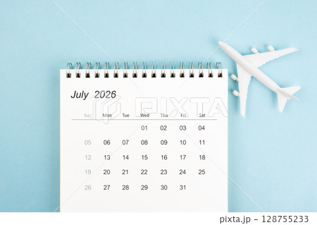 July 2026 calendar and airplane toy on blue color background, Travel plan concepts. 128755233