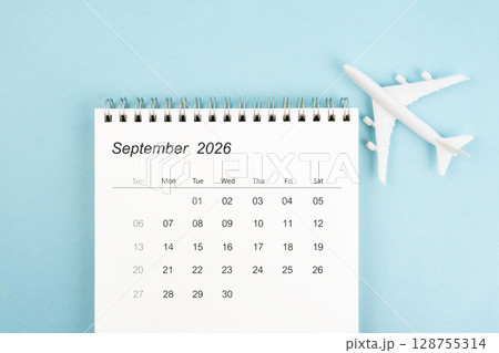 September 2026 calendar and airplane toy on blue color background, Travel plan concepts. September 2026 calendar and airplane toy on blue color background, Travel plan concepts. 128755314