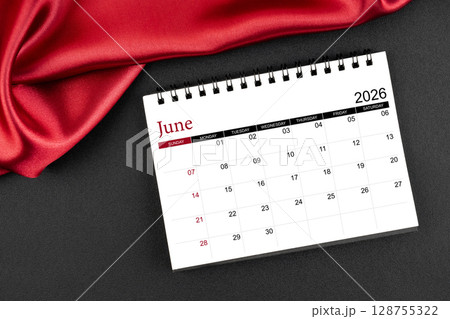 June 2026 Monthly desk calendar with red silk on black color leather background. 128755322