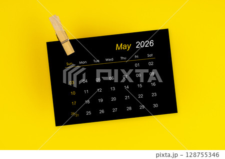 May 2026 black calendar with wooden clip on yellow color background. May 2026 black calendar with wooden clip on yellow color background. 128755346