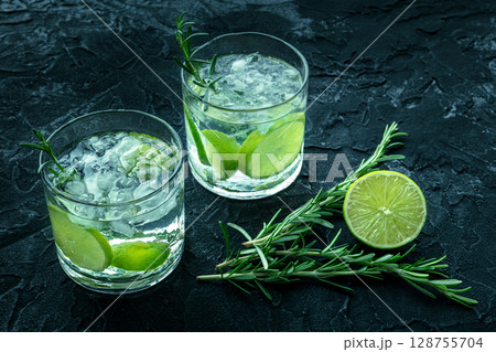 Gin tonic, two glasses of gin with soda, lime, rosemary, and plenty of ice 128755704