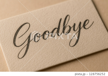 Close-Up of Elegant Scripted Goodbye Inscription on Textured Card Stock 128756252