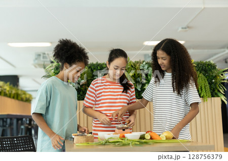 group of multi-ethnic children girls are learning how to cooking with miniature kitchen utensils, teamwork student education up skill make food. 128756379