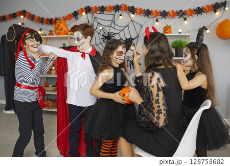 Artist doing spooky makeup to a group of children at a fun Halloween party at home 128758682