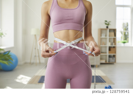 Slim woman who's been working out shows how many centimeters she's lost off her waist 128759541