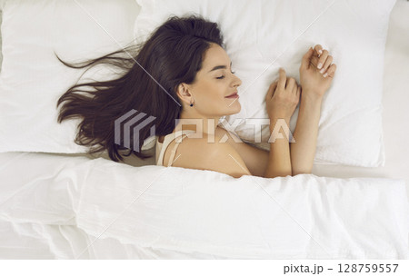 View from above of relaxed beautiful young woman sleeping on white pillow in her bed 128759557