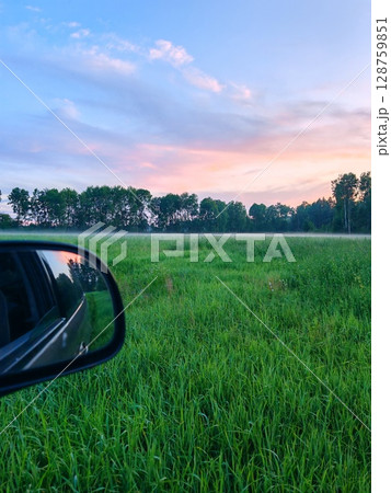 Beautiful summer landscape and peaceful view in the rainy season. vast green fields stretch out in front of us. evening, covered with thick fog 128759851