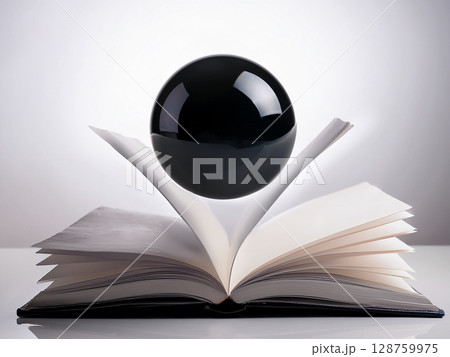 開いた本の上に黒色の球が浮かんでいる 開いた本の上に黒色の球が浮かんでいる 128759975