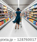 Woman Shopping in Supermarket Aisle with Grocery Cart 128760017