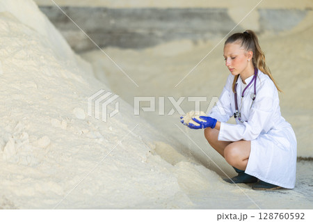 Female veterinarian checking the quality of powdered cow feed 128760592