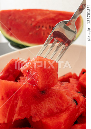 Fresh watermelon slices on a plate with a fork ready to enjoy juicy summer fruit Fresh watermelon slices on a plate with a fork ready to enjoy juicy summer fruit 128761874