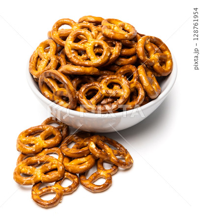 Small traditional beer pretzels with salt in a white ceramic bowl isolated on white background 128761954
